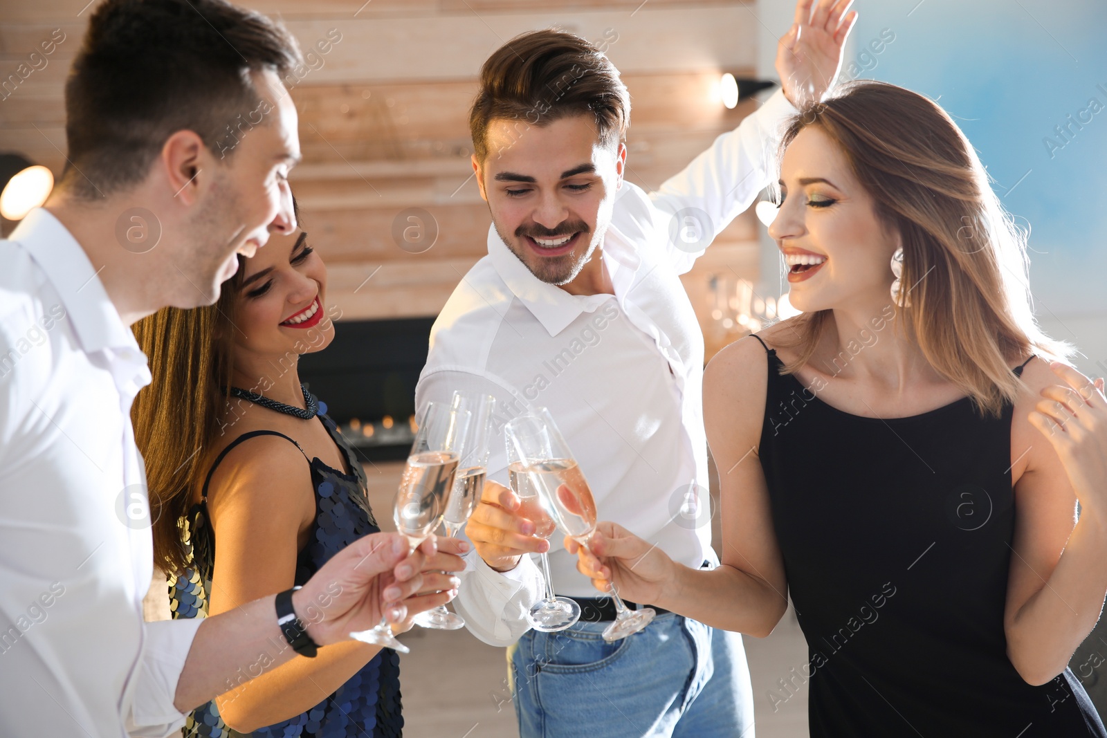 Photo of Friends clinking glasses with champagne at party indoors