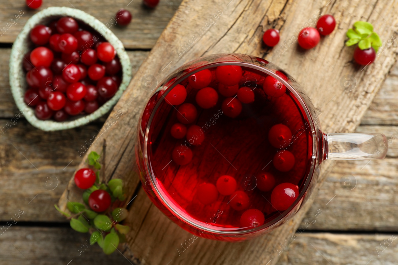 Photo of Delicious cranberry tea and berries on wooden table, flat lay