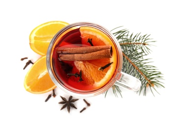 Photo of Glass cup of mulled wine with fir branch, cinnamon and orange isolated on white, top view