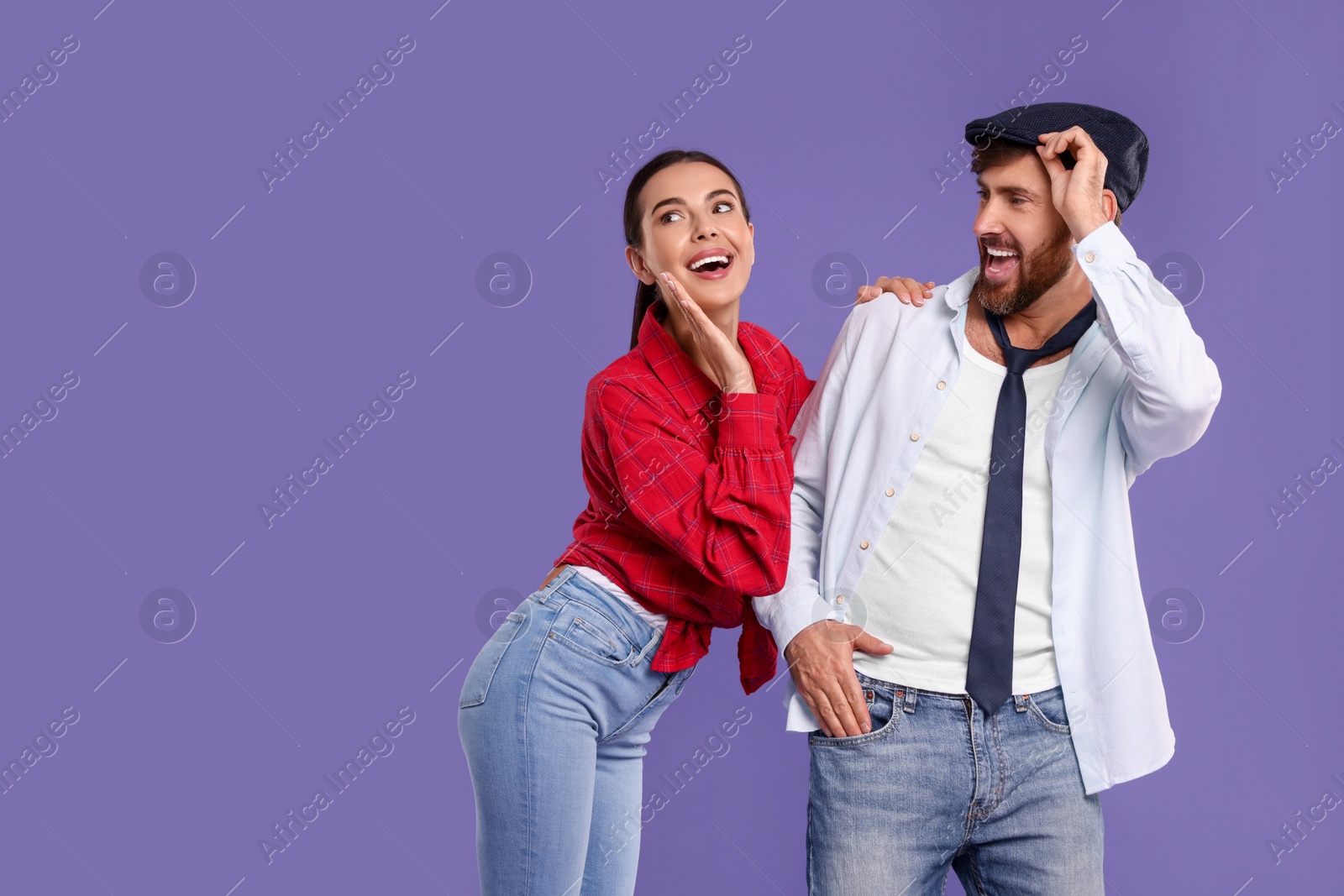 Photo of Happy couple dancing together on violet background, space for text