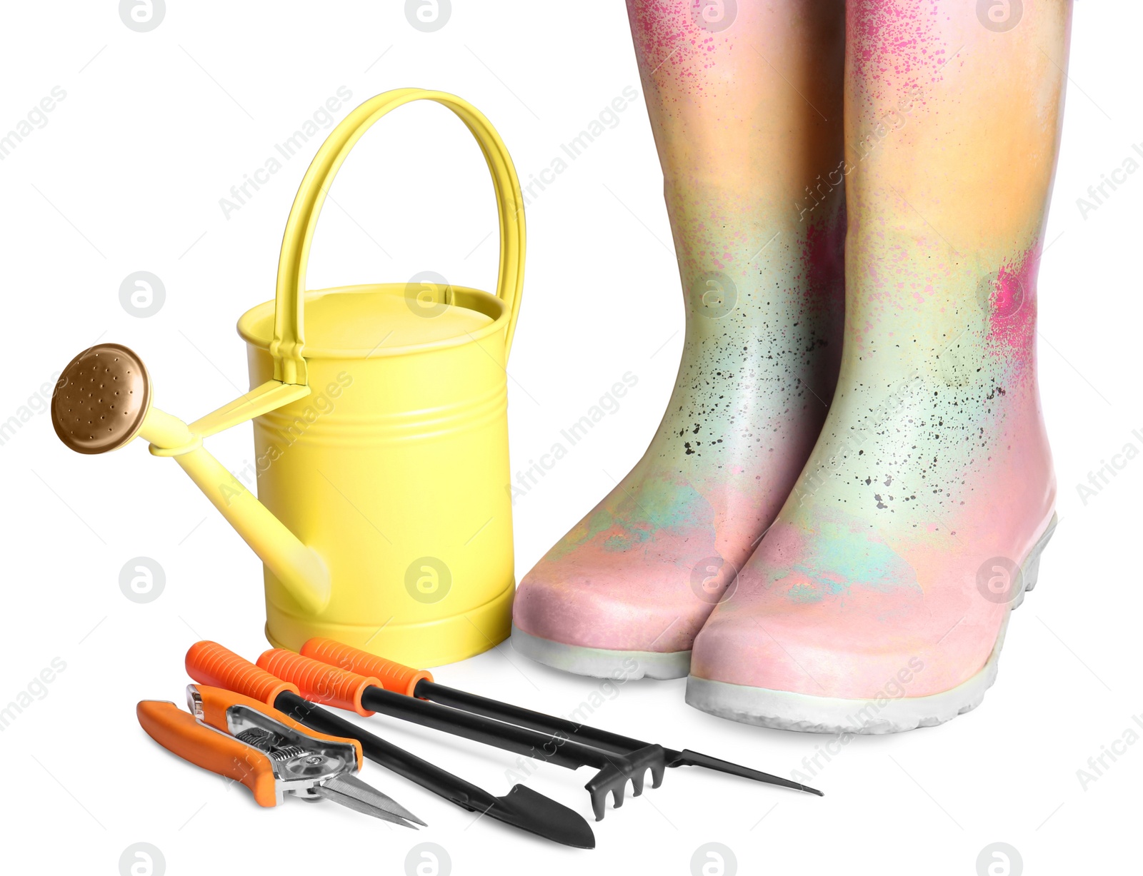 Photo of Watering can, rubber boots and gardening tools on white background