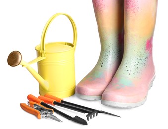 Photo of Watering can, rubber boots and gardening tools on white background
