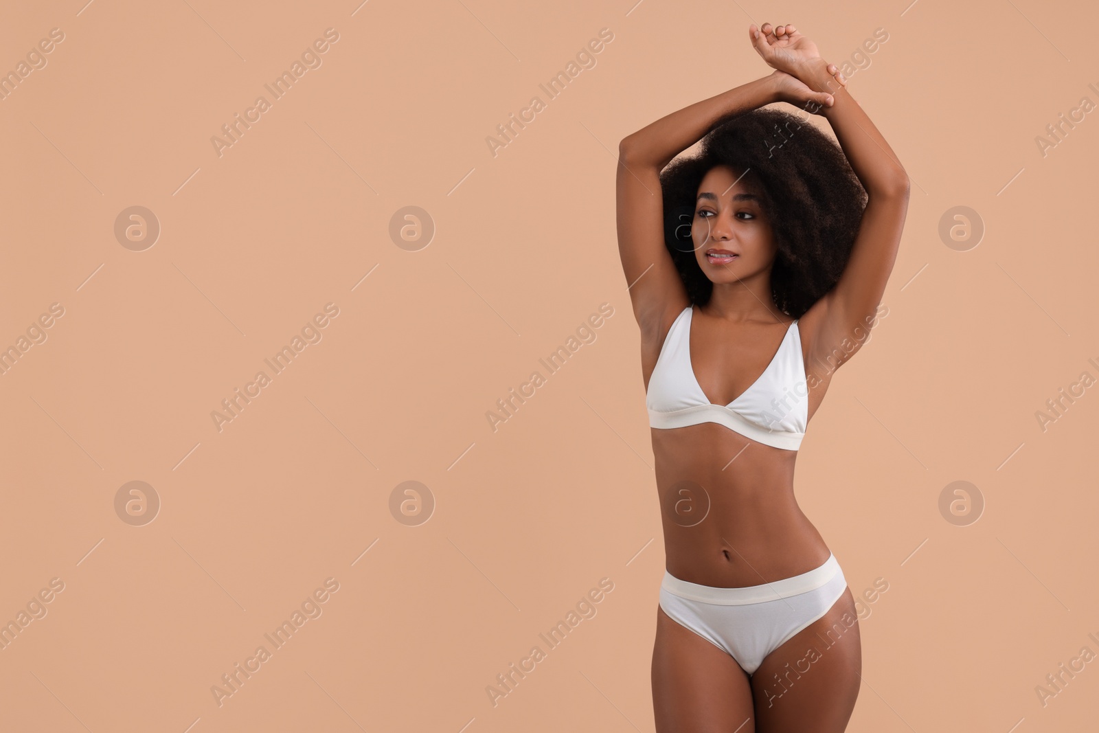 Photo of Beautiful woman in stylish bikini on beige background, space for text