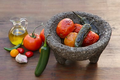 Photo of Ingredients for tasty salsa sauce and stone bowl on wooden table