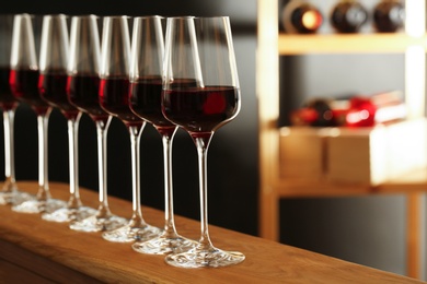 Photo of Glasses of red wine in cellar, space for text. Expensive drink