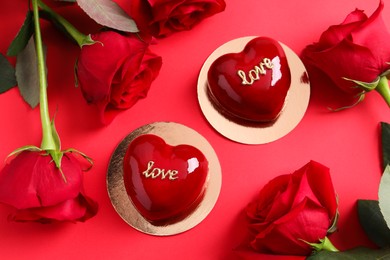 Photo of St. Valentine's Day. Delicious heart shaped cakes and roses on red background, flat lay