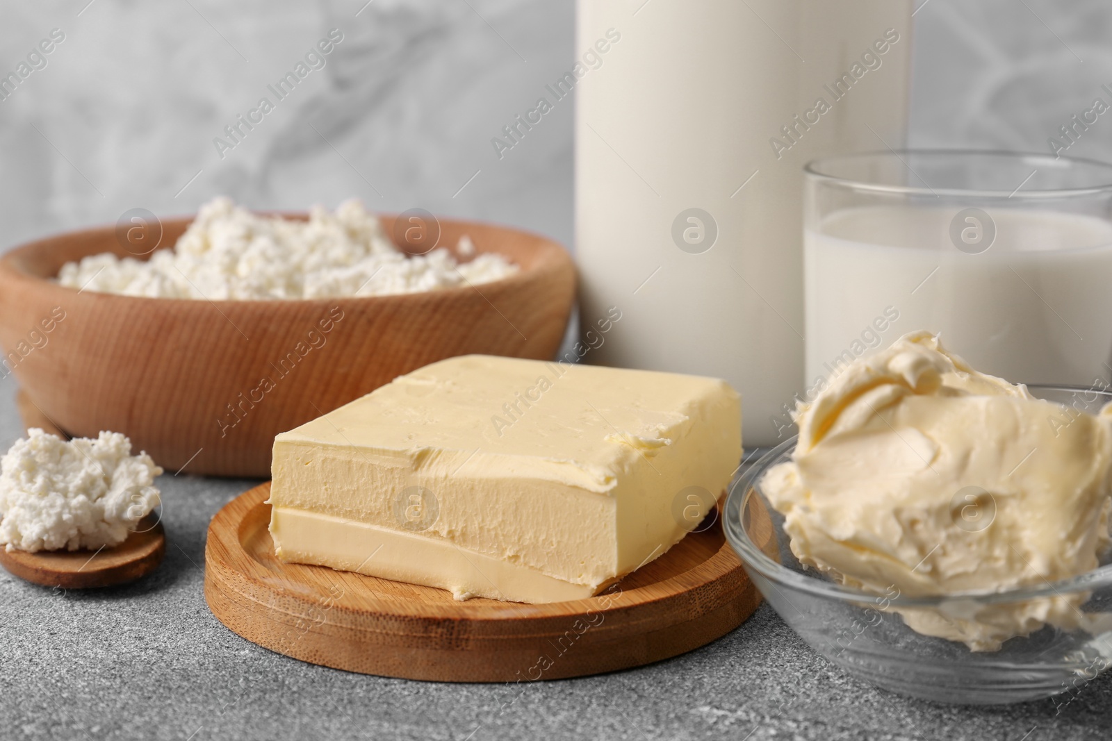 Photo of Piece of tasty homemade butter and dairy products on grey table