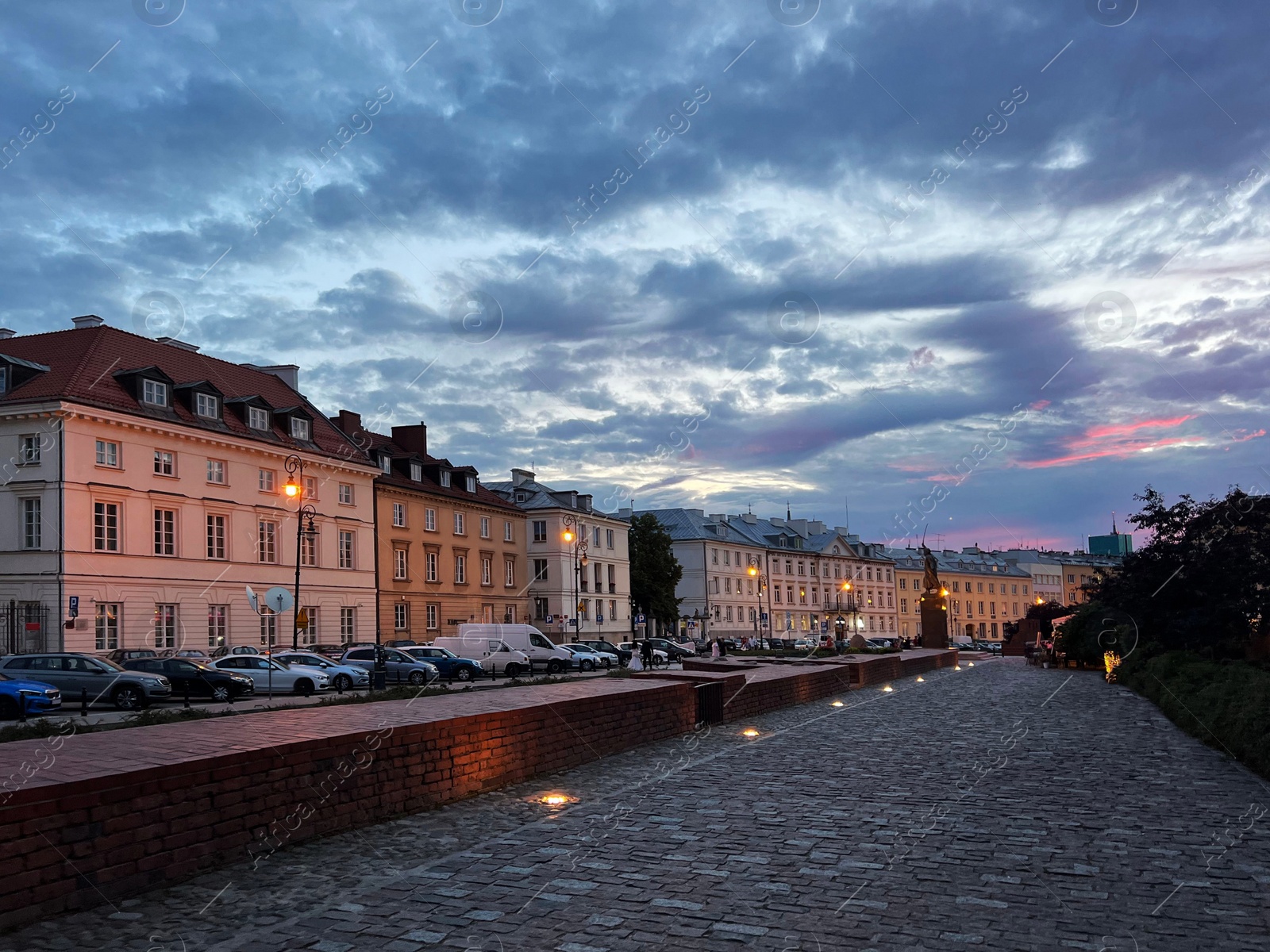 Photo of Cityscape with cars parked along street in evening