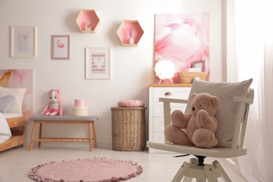 Photo of Teddy bear on chair in modern teenager's room. Space for text