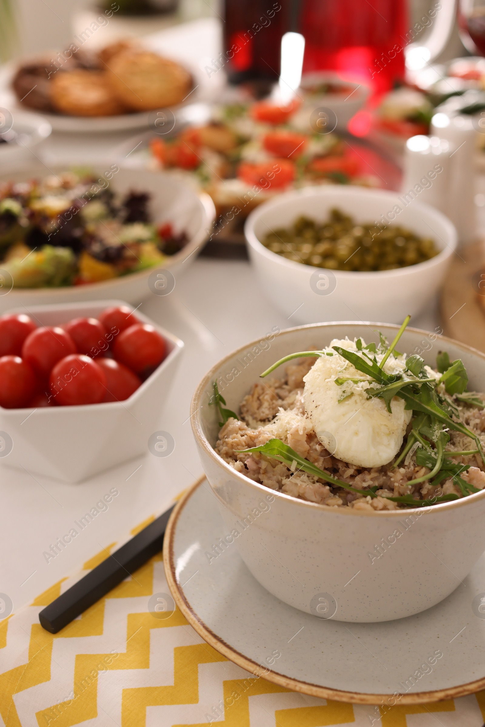 Photo of Bowl of oatmeal with poached egg, arugula and cheese served on buffet table for brunch