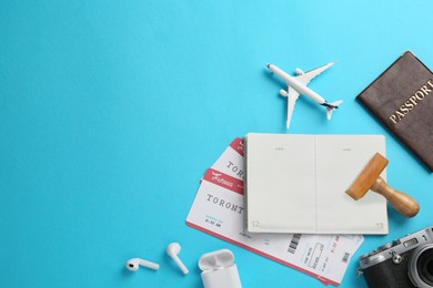 Photo of Flat lay composition with passports, stamp and flight tickets on light blue background, space for text