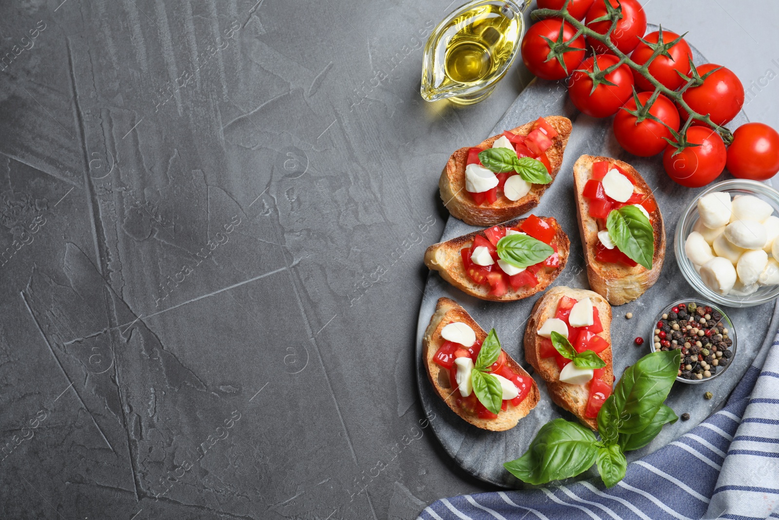 Photo of Delicious bruschettas with cheese and tomatoes on grey table, flat lay. Space for text
