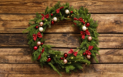 Photo of Beautiful Christmas wreath with festive decor on wooden background, top view