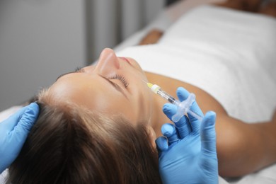 Photo of Beautiful woman getting facial injection in salon
