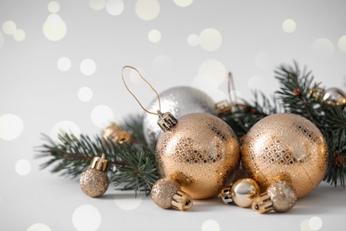 Image of Beautiful Christmas balls and fir tree branches on table, bokeh effect