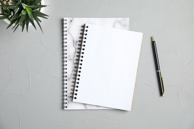 Photo of Flat lay composition with notebooks and plant on grey background