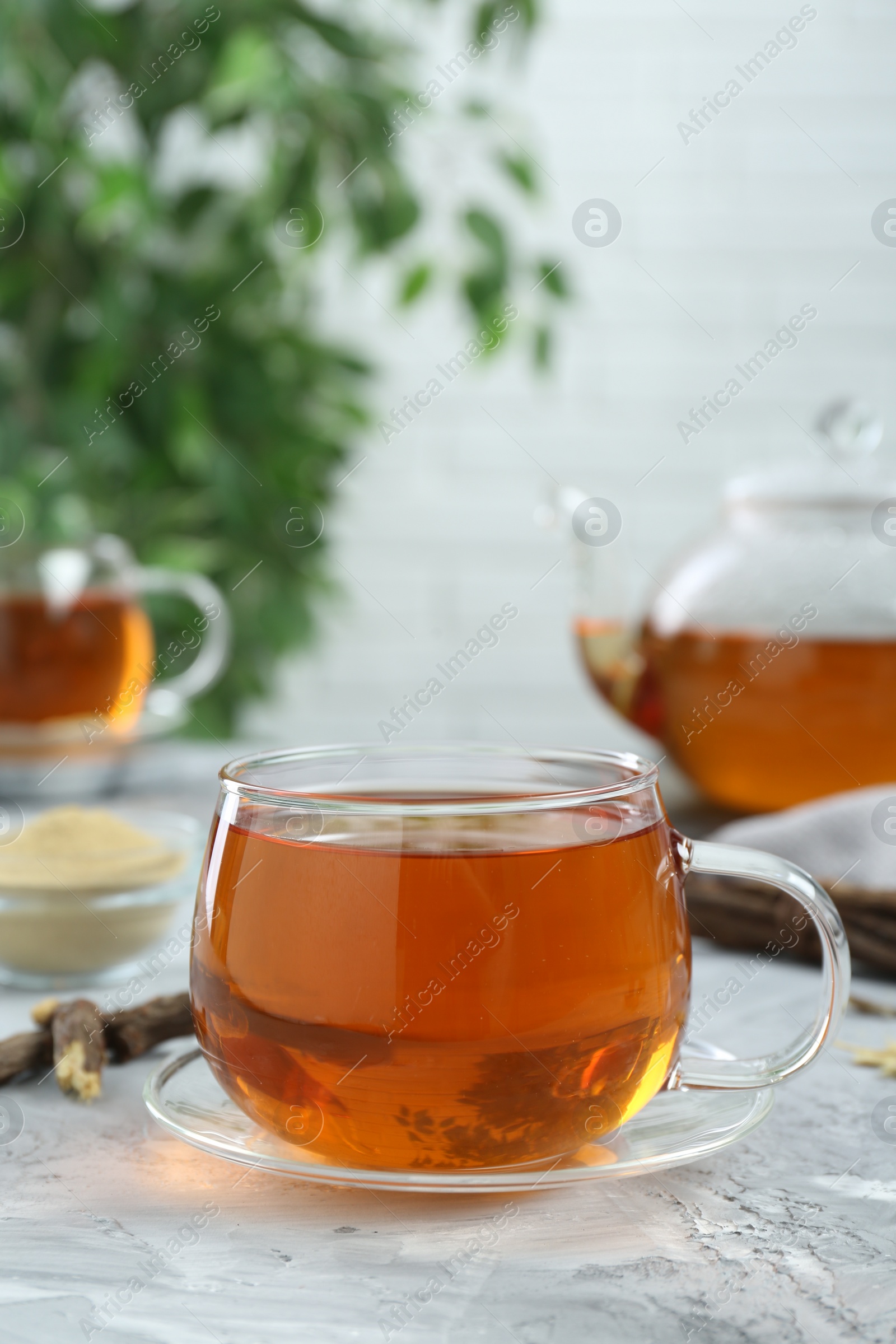 Photo of Aromatic licorice tea on light gray textured table, space for text