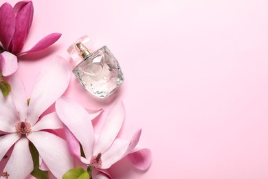 Photo of Beautiful magnolia flowers and bottle of perfume on pink background, flat lay. Space for text