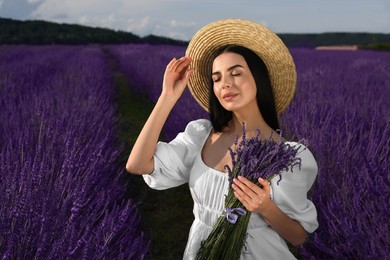 Beautiful young woman with bouquet in lavender field