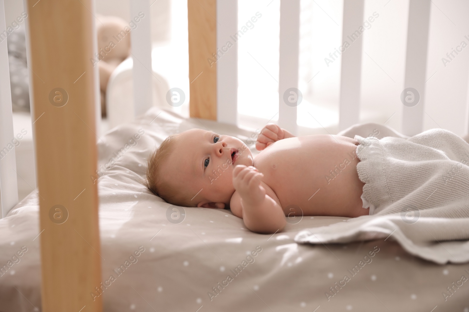 Photo of Cute little child lying in cot. Healthy baby