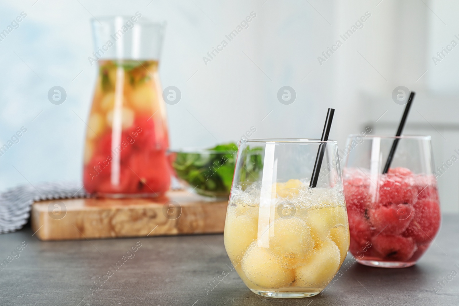 Photo of Glasses with tasty watermelon and melon ball drinks on table