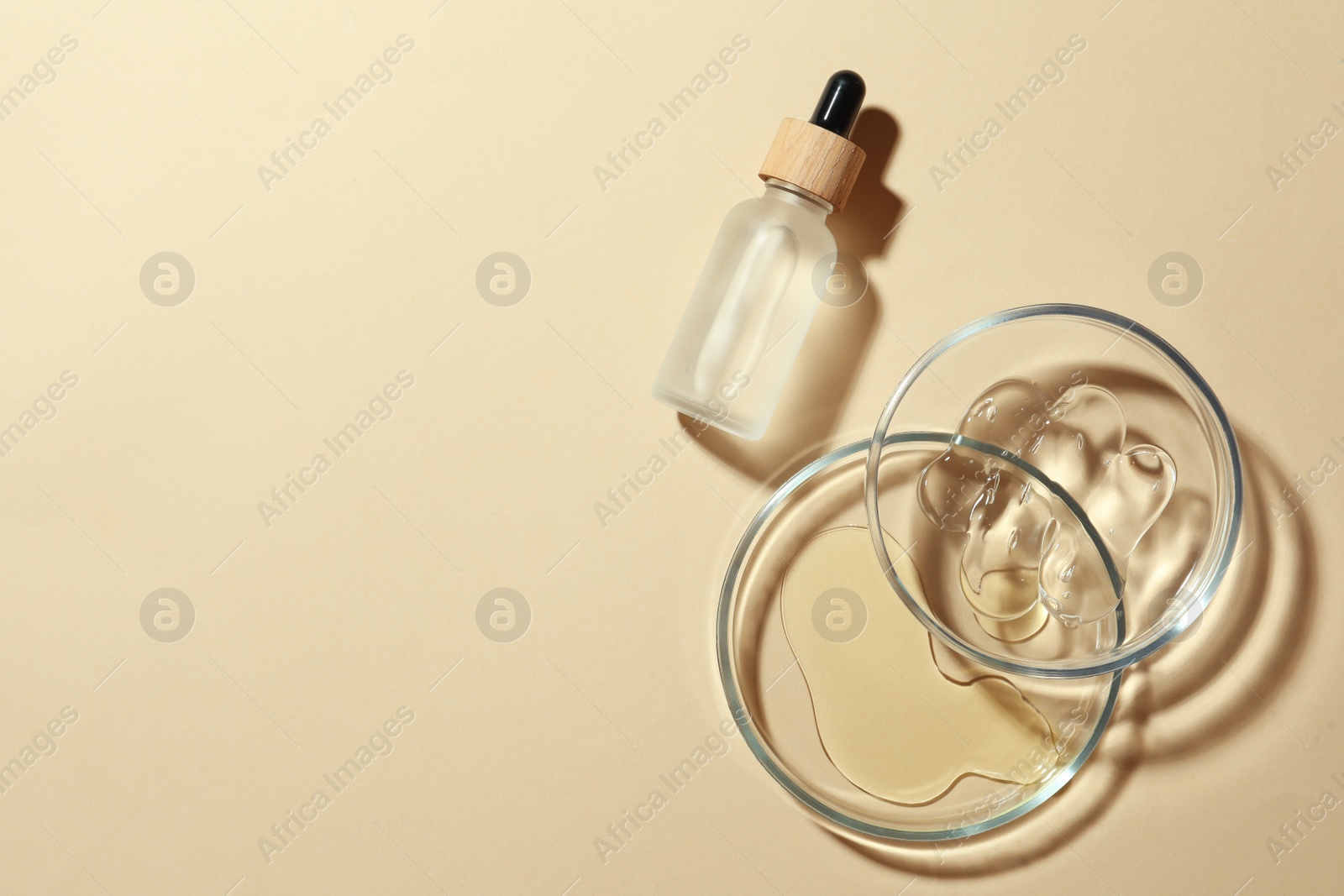 Photo of Petri dishes and cosmetic products on beige background, flat lay. Space for text