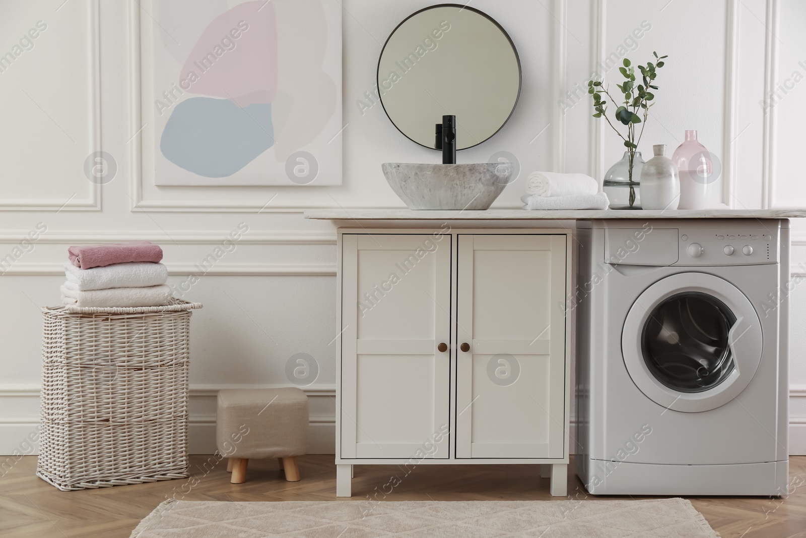 Photo of Laundry room interior with modern washing machine and stylish vessel sink on countertop