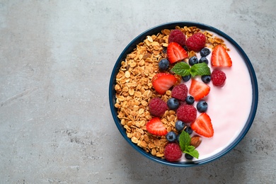 Healthy homemade granola with yogurt on grey table, top view. Space for text