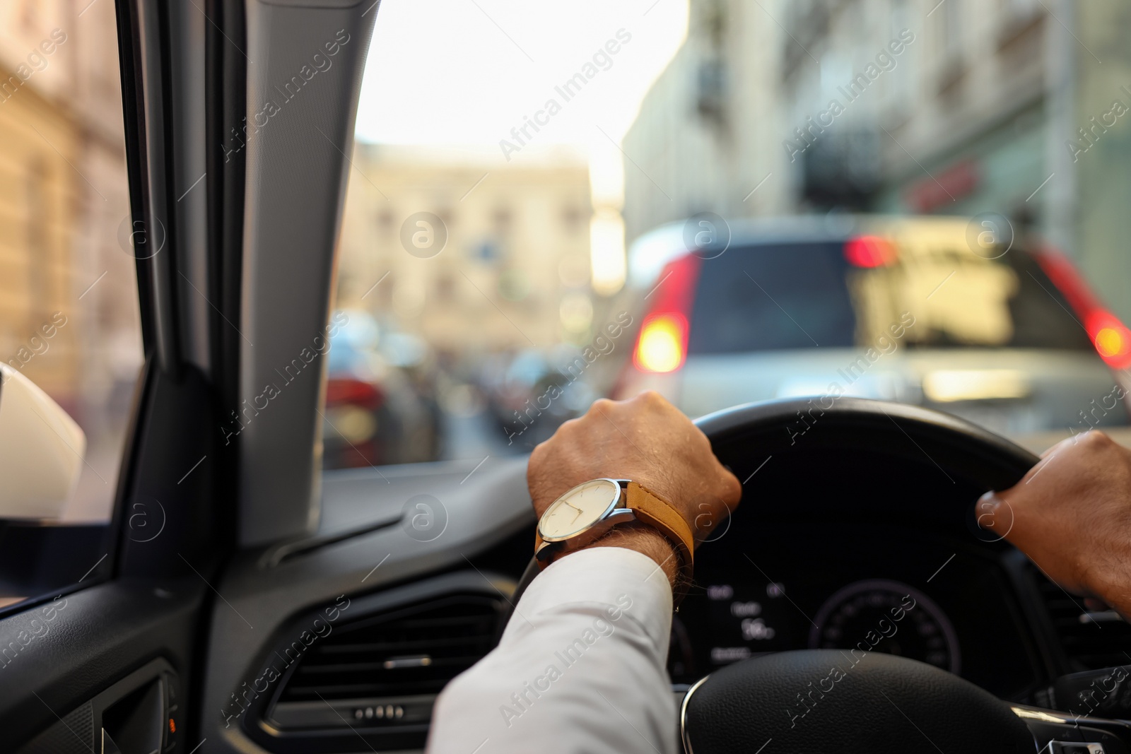 Photo of Stuck in traffic jam. Driver holding hands on steering wheel in car, closeup