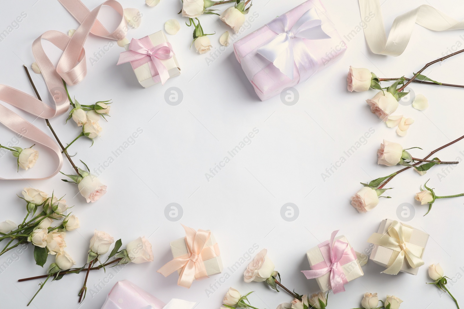 Photo of Flat lay composition with beautiful roses and gift boxes on white background. Space for text