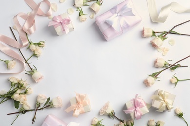 Flat lay composition with beautiful roses and gift boxes on white background. Space for text