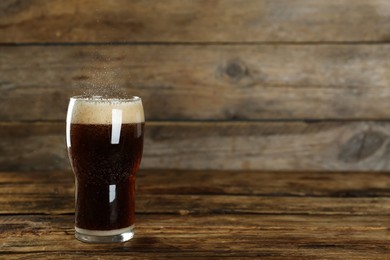 Photo of Glass of refreshing soda water on wooden table, space for text