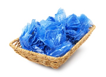 Photo of Blue medical shoe covers in wicker basket isolated on white