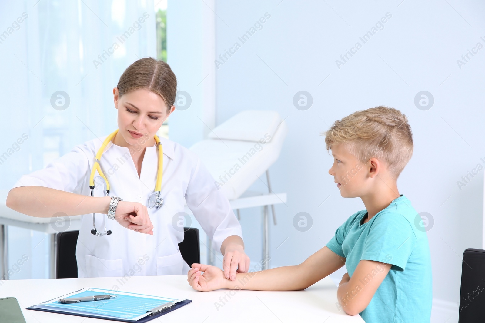 Photo of Doctor checking little boy's pulse in hospital