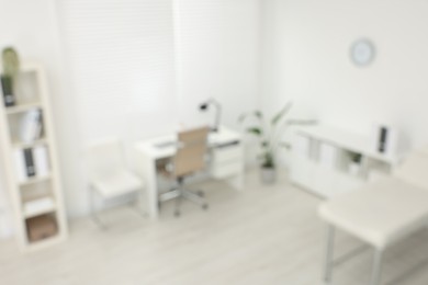 Photo of Blurred view of modern medical office with doctor's workplace in clinic