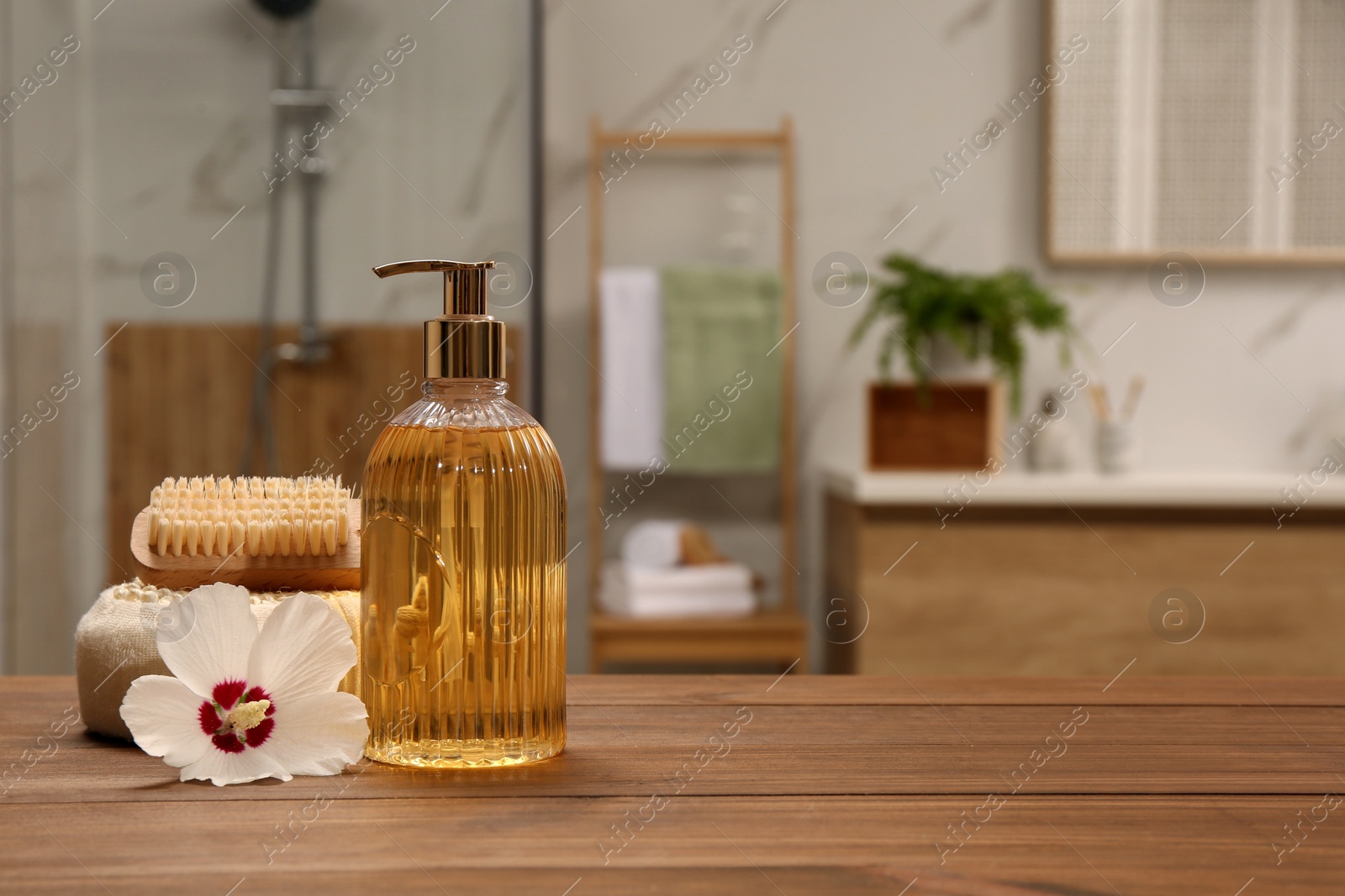 Photo of Composition with liquid soap in glass dispenser on  wooden table indoors
