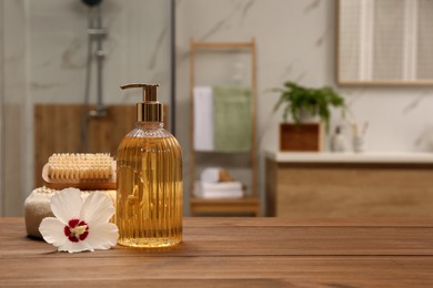 Photo of Composition with liquid soap in glass dispenser on  wooden table indoors