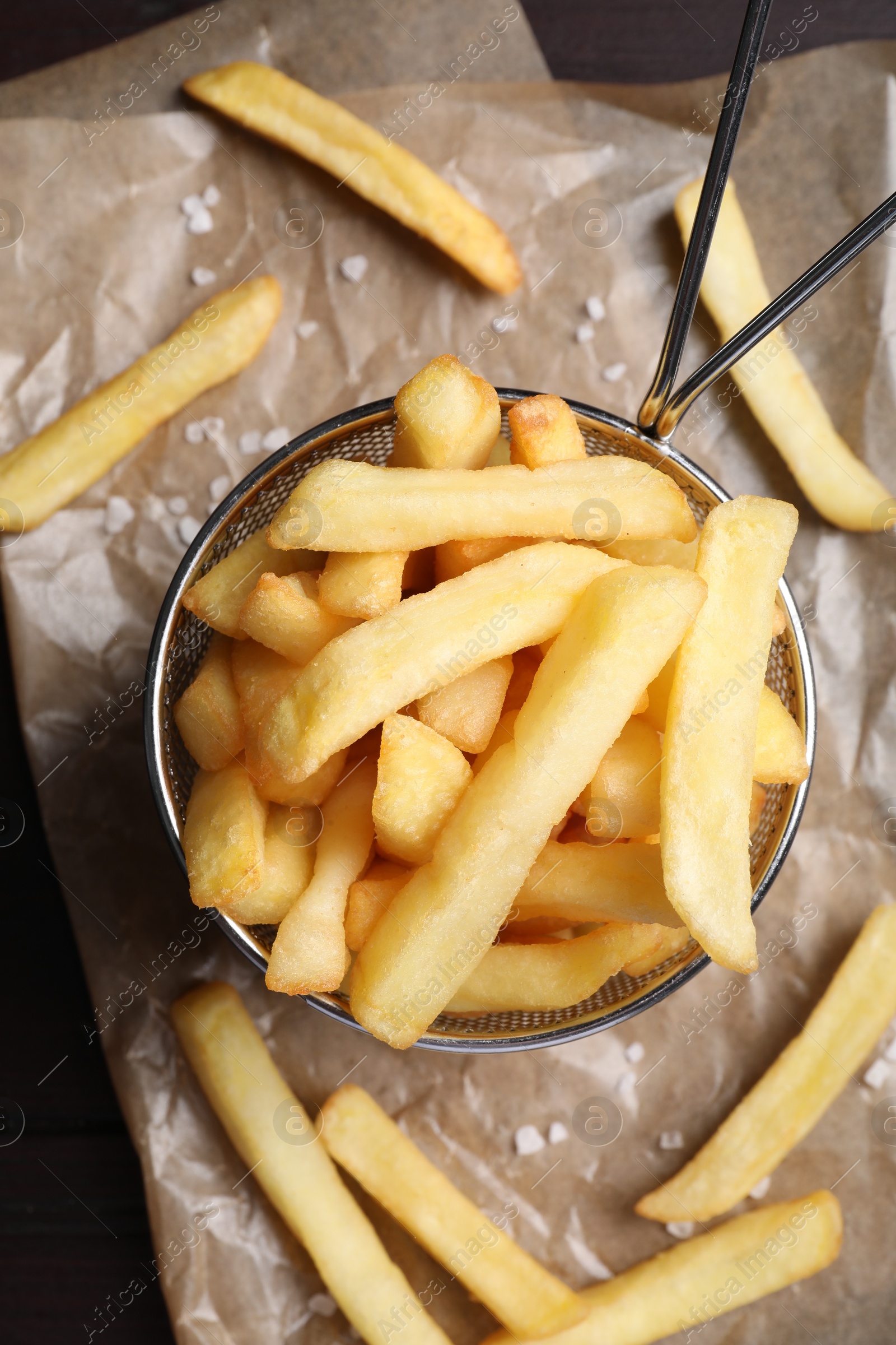 Photo of Frying basket with tasty french fries on table, flat lay