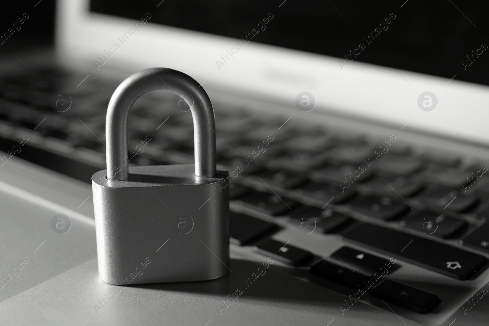 Photo of Metal lock on laptop, closeup. Cyber security concept