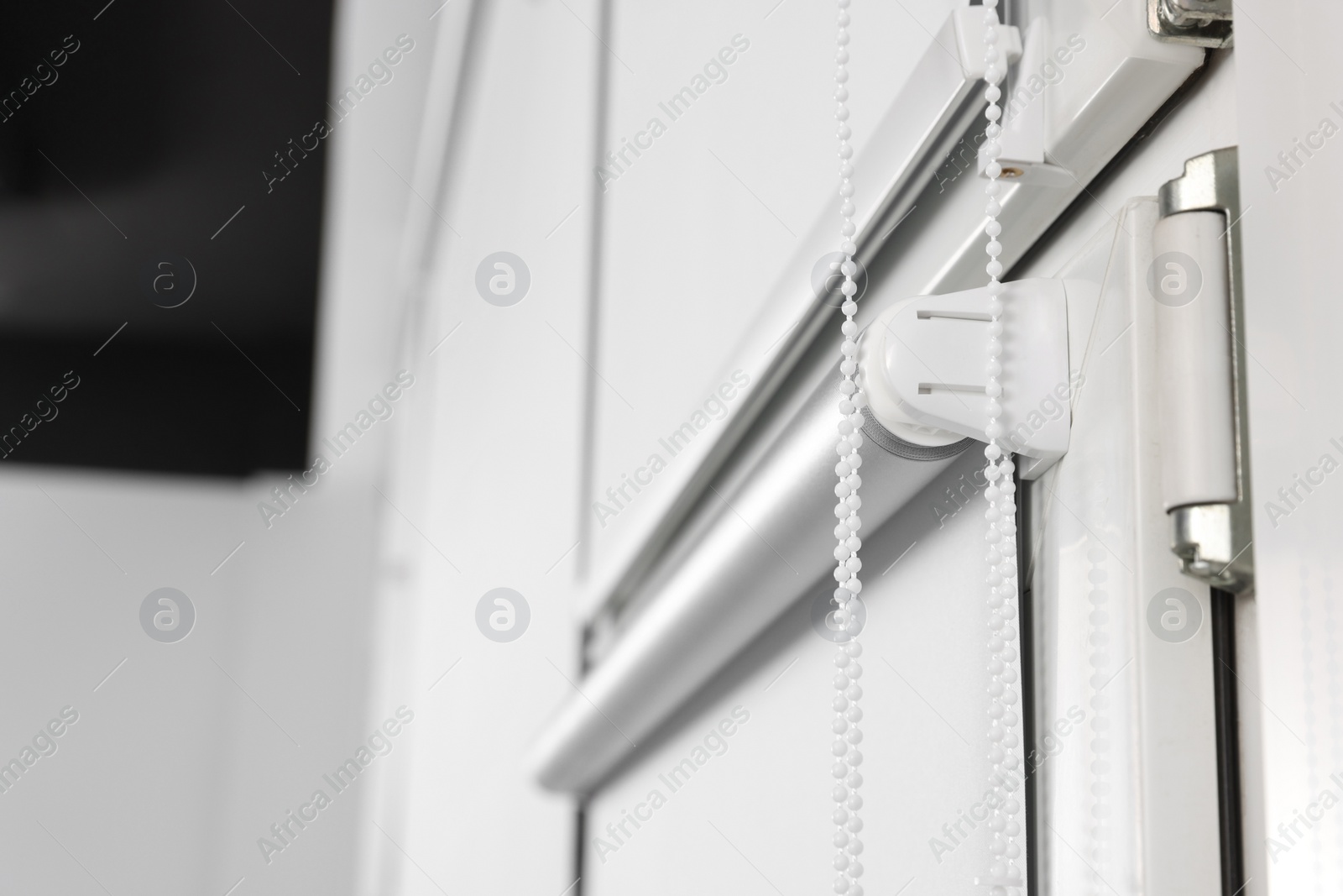 Photo of Window with white roller blinds indoors, closeup