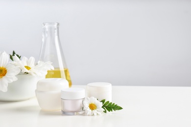 Skin care products, ingredients and laboratory glassware on table, space for text. Dermatology research