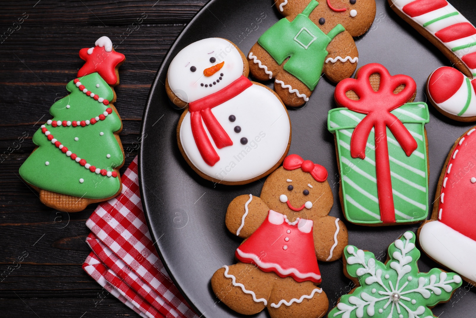 Photo of Delicious Christmas cookies on black wooden table table, flat lay