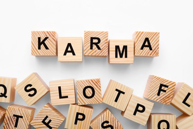 Photo of Word Karma made of cubes with letters on white background, flat lay