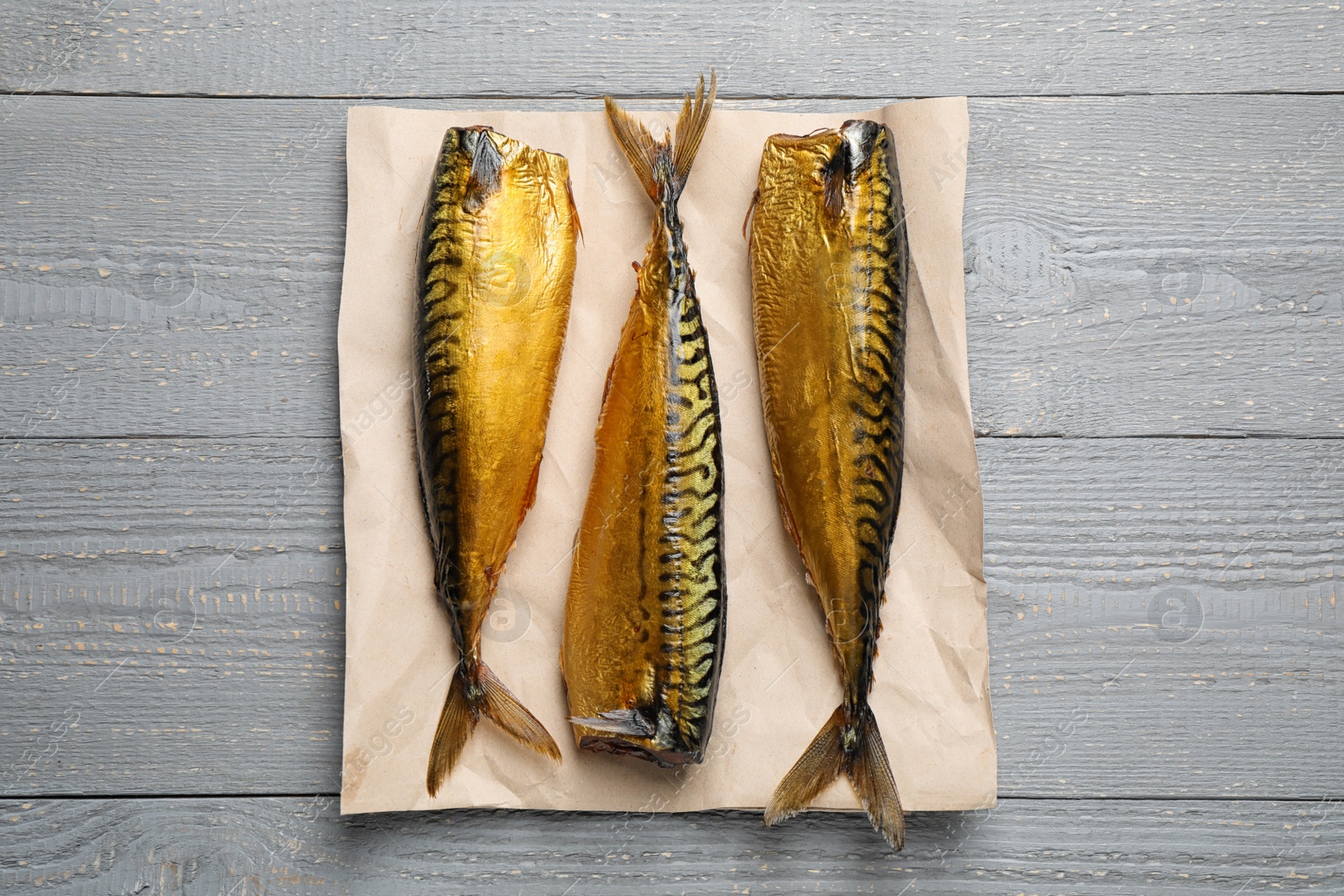 Photo of Tasty smoked fish on wooden table, top view