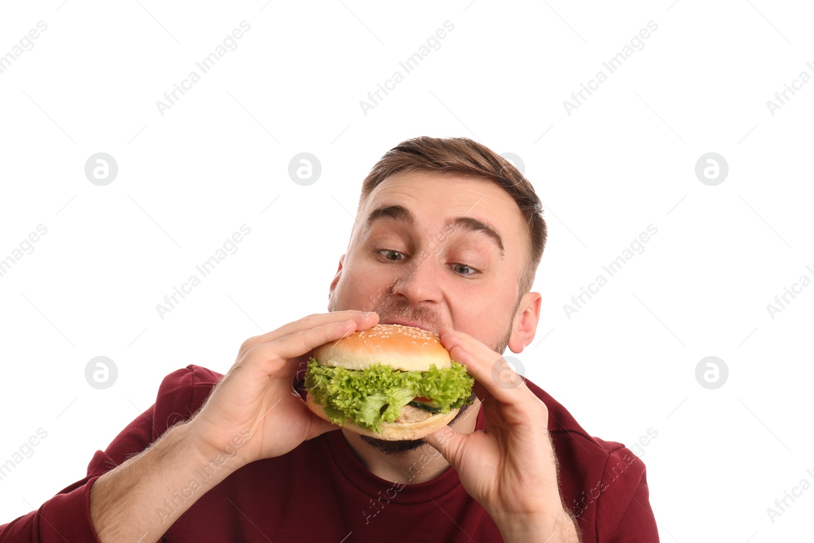 Photo of Young man eating tasty burger on white background