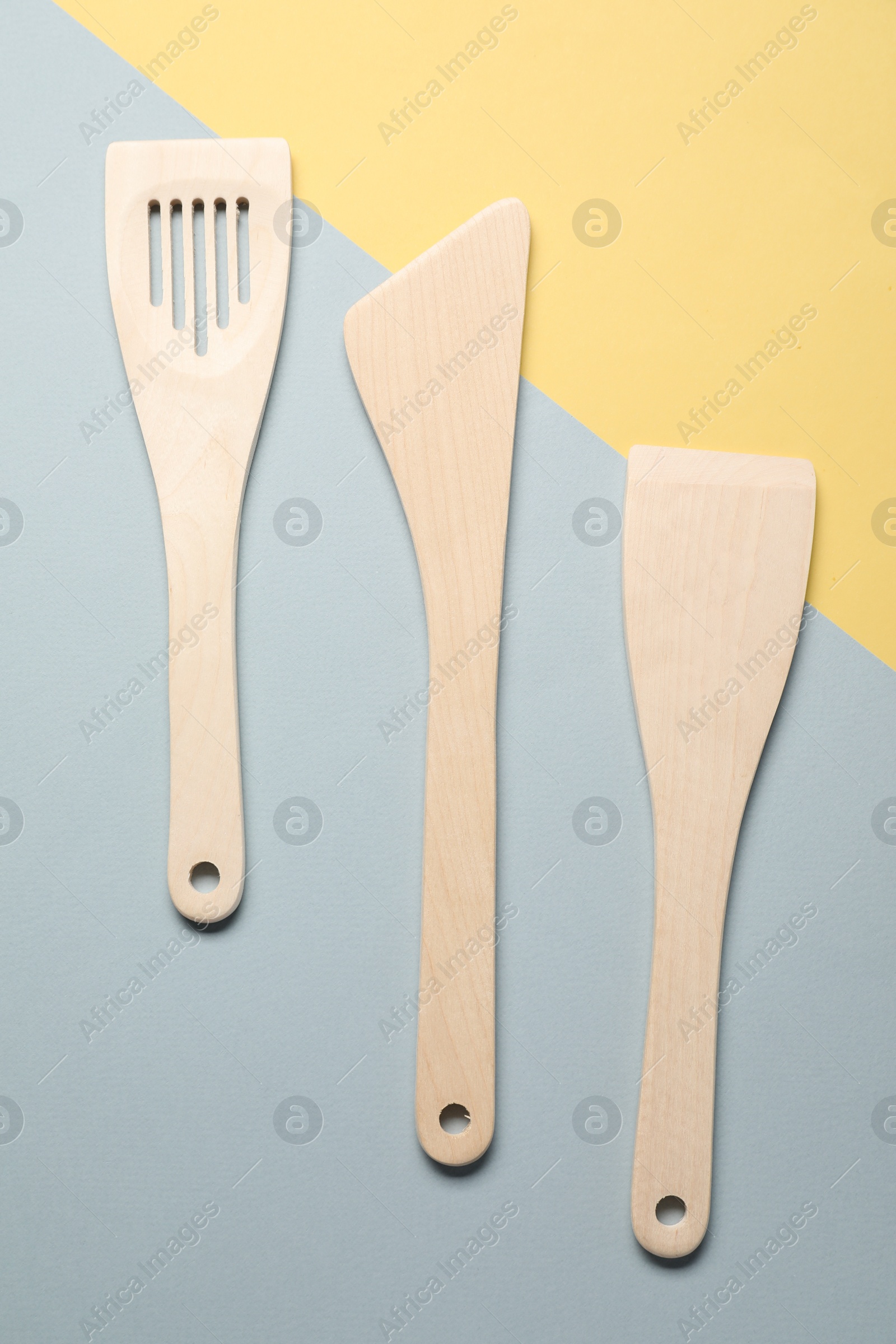 Photo of Different wooden spatulas on color background, flat lay