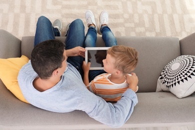 Father with child using tablet at home. Happy family