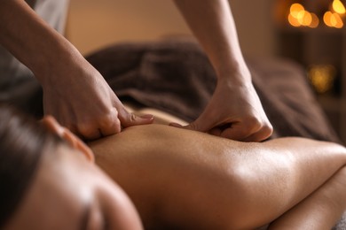 Spa therapy. Beautiful young woman lying on table during massage in salon, closeup
