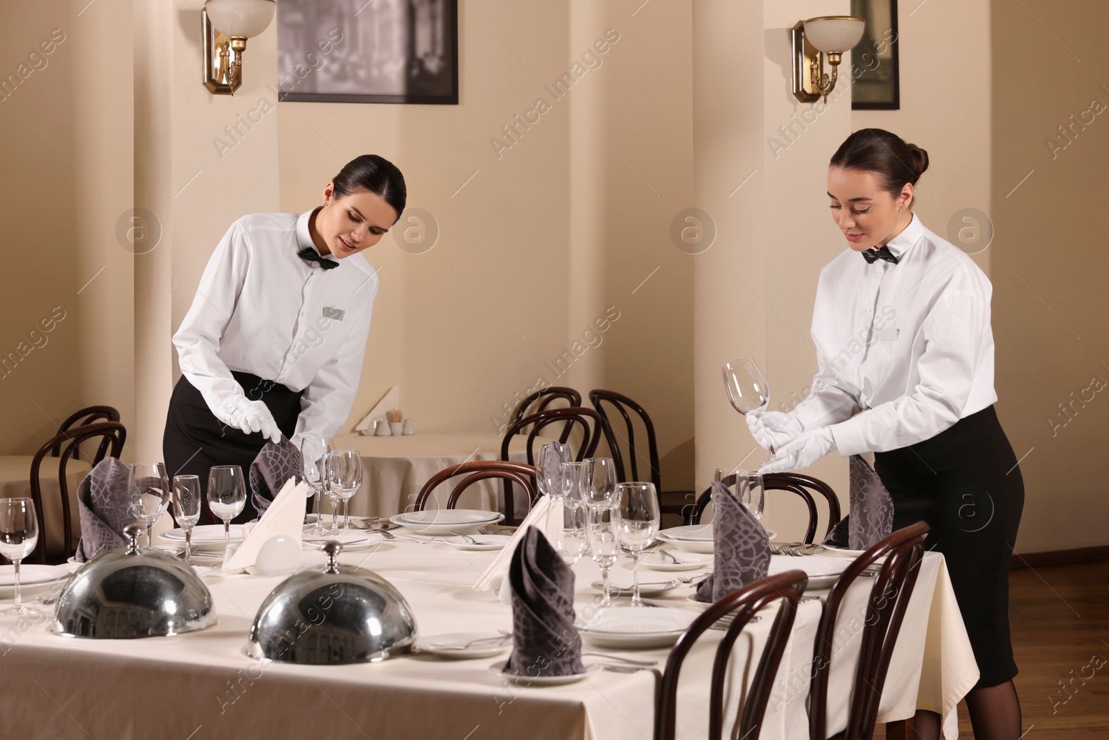 Photo of People setting table during professional butler courses in restaurant