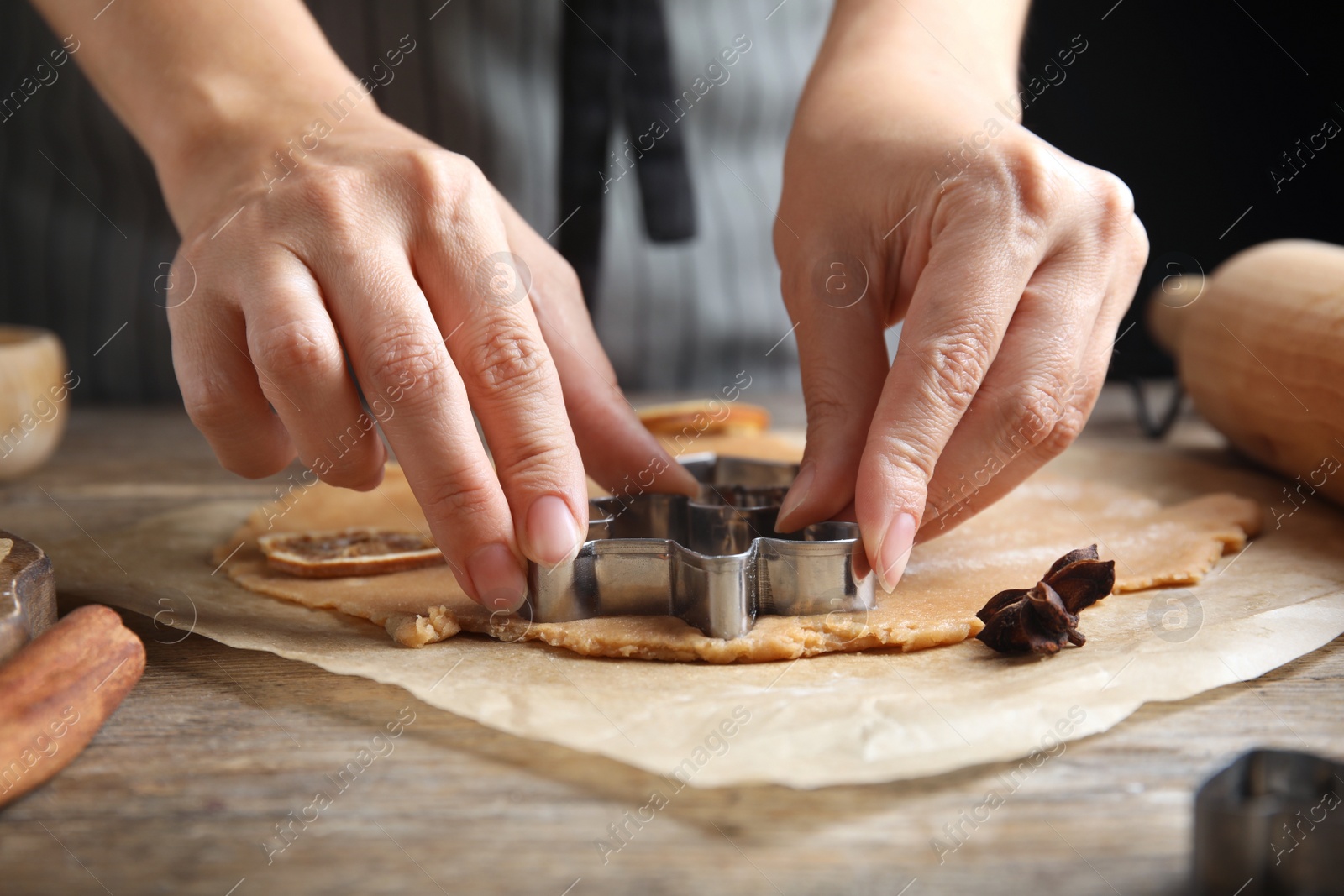 Photo of Woman making Christmas cookies at wooden table, closeup